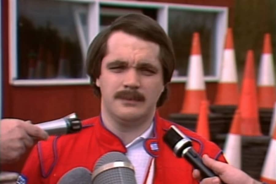Steve Pising being interviewed, multiple microphones in his face