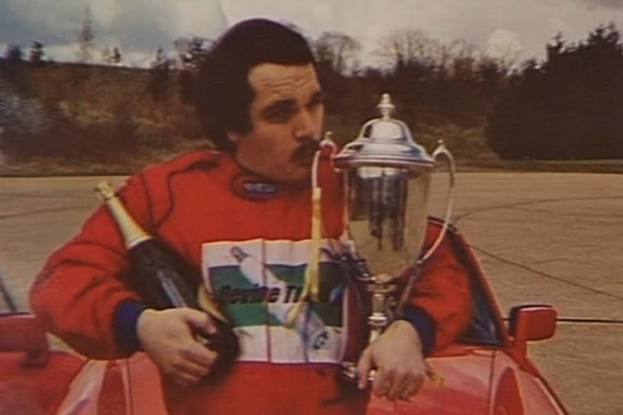 Steve Pising kissing a tropy and holding champagne