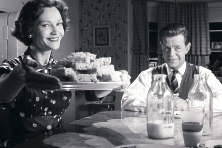 Betty offers a plate of Rice Krispies squares at the table