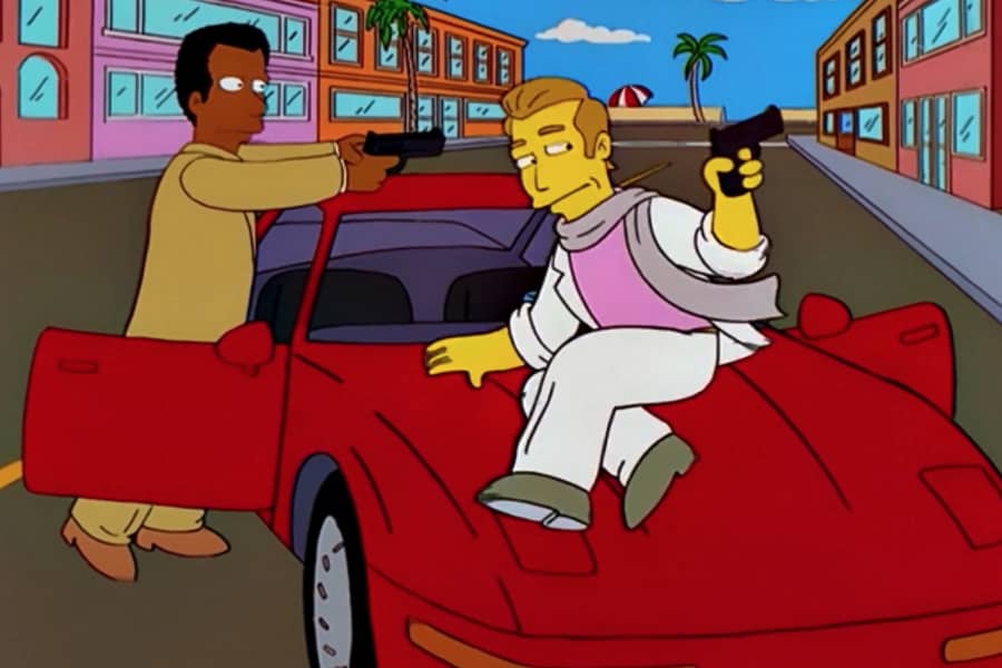 Simpson, gun in hand, slides across a car hood while Kaufman aims his gun from behind the car