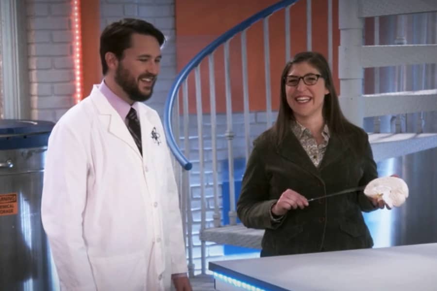 Wheaton talks with Dr. Amy Farrah Fowler who is pointing at a model brain