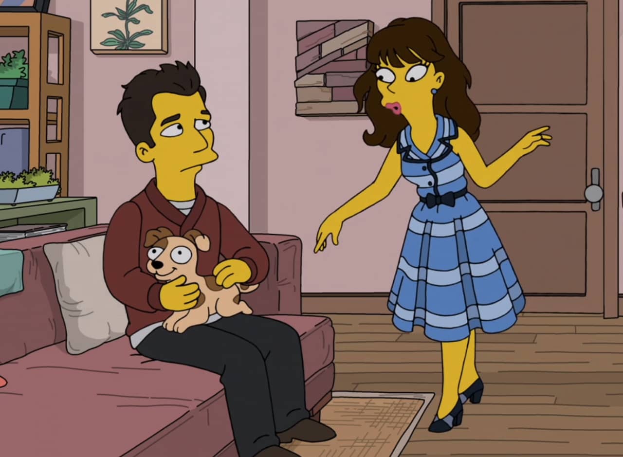 woman in a cute dress talking to a guy on the couch with a puppy