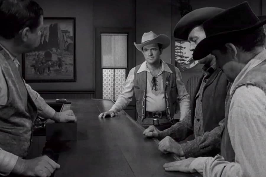 McGrew talking with men and a bartender