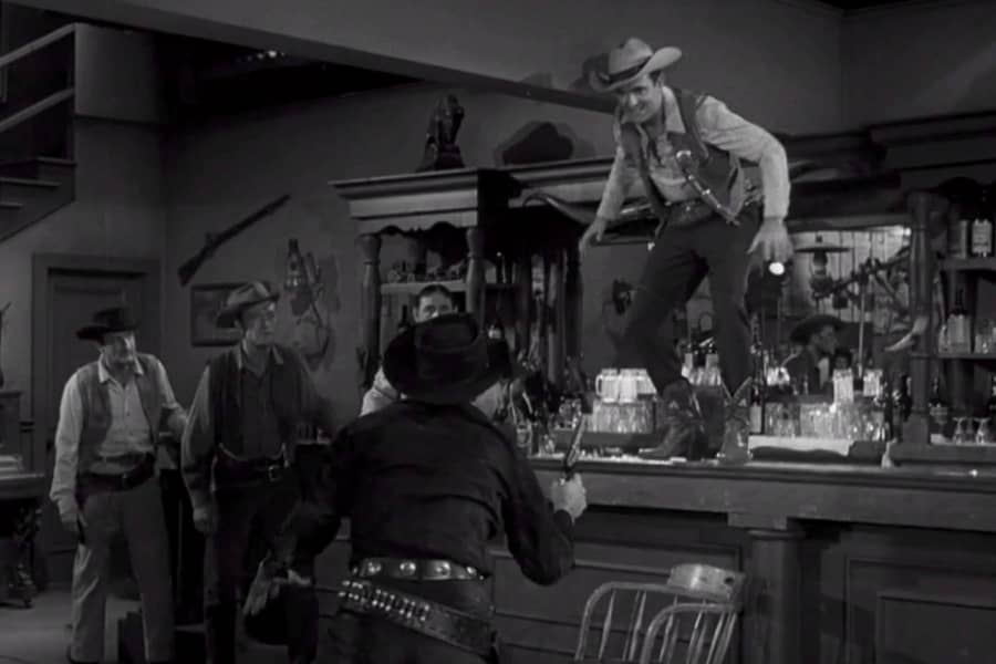 McGrew standing on the bar, the man in black standing below