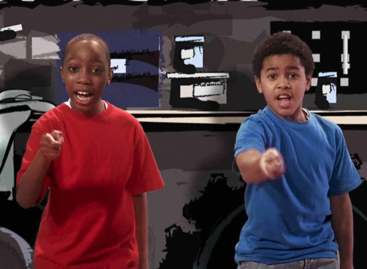 two young kids singing with coordinated hand motions