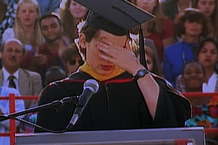Lelaina covering her face while giving a graduation speech