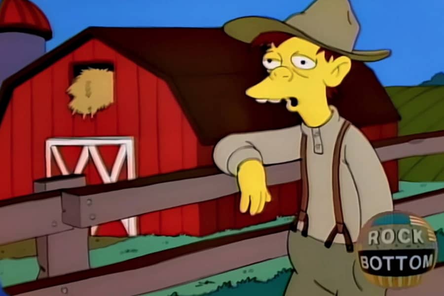 farm worker in front of a barn