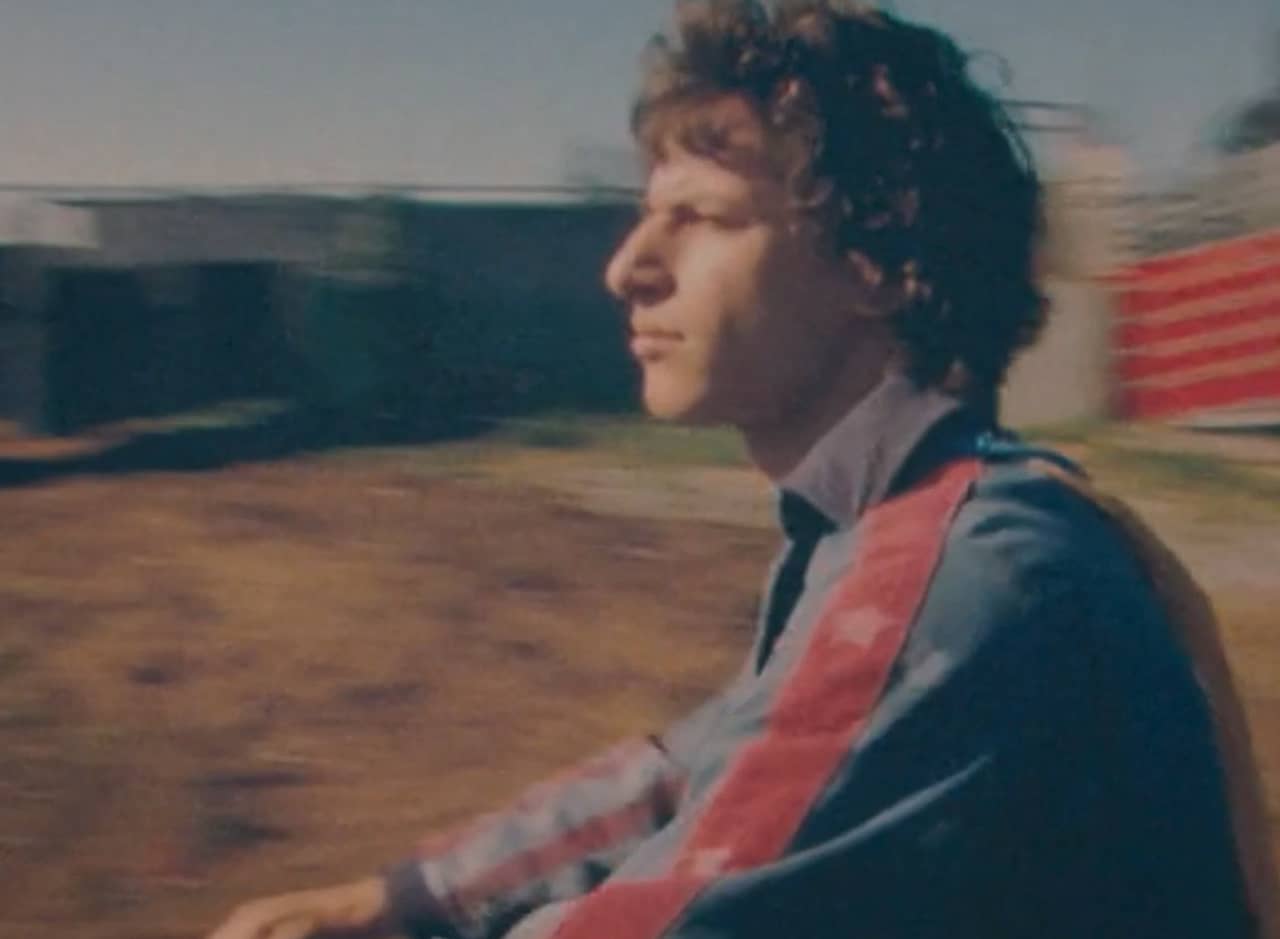 Rod Kimble, a curly haired young man, wearing a stuntman jumpsuit and looking off into the distance