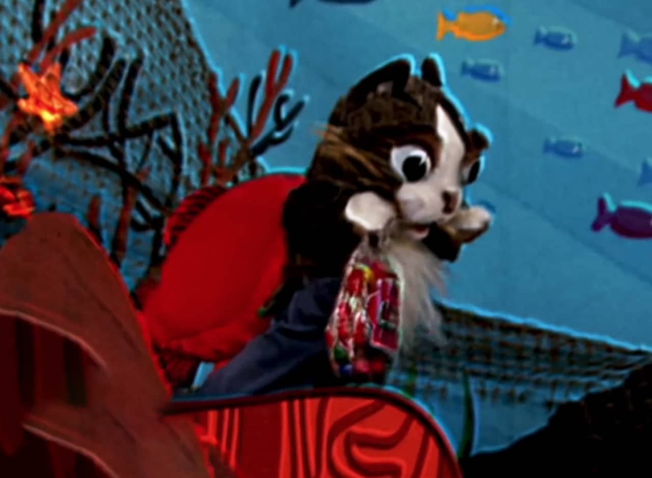 in the ocean, puppet cat with a fish tail and holding a bag of candy
