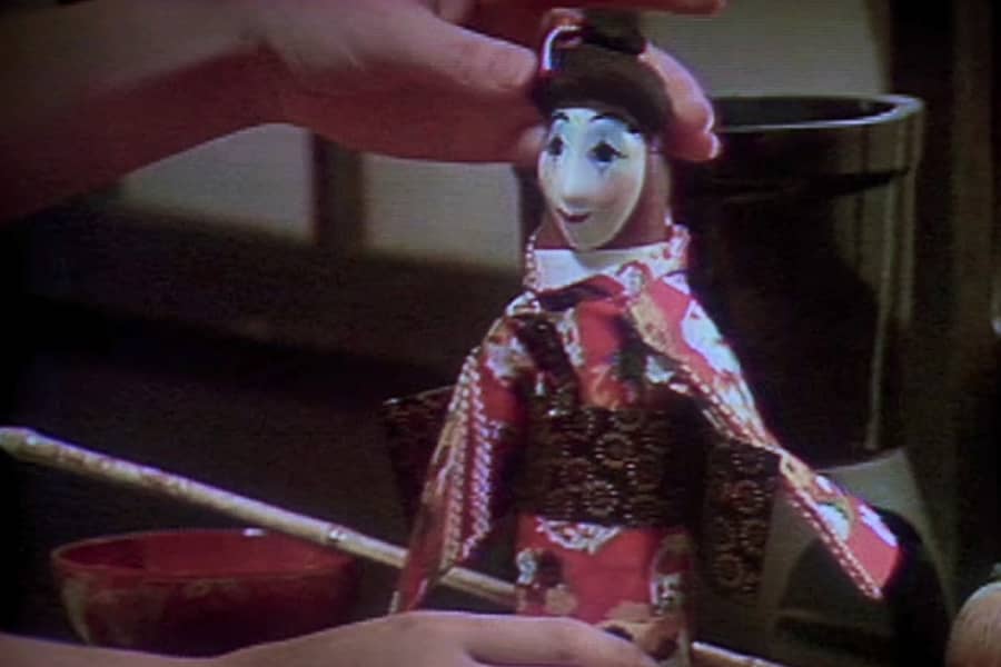 a dildo with a geisha costume and mask on it