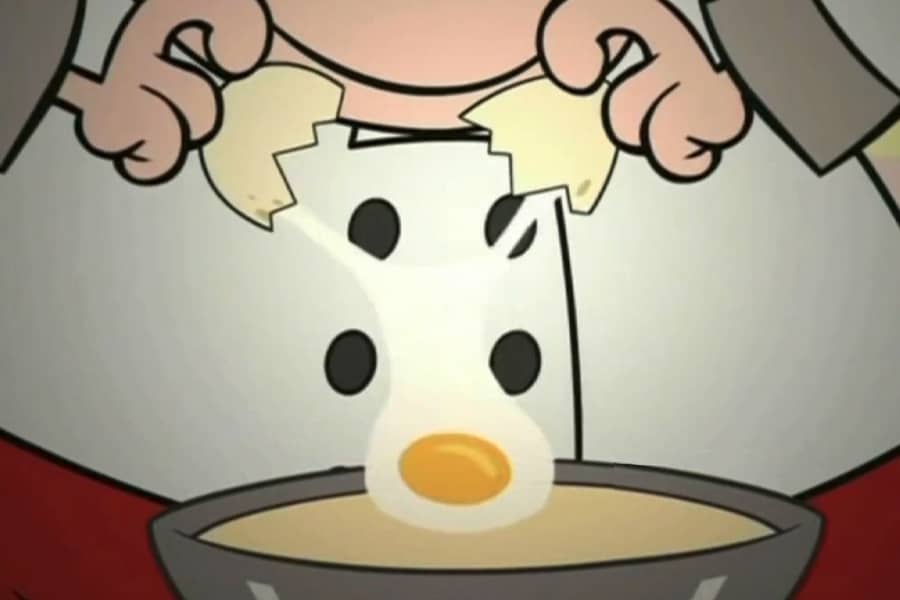 chef cracking an egg into the batter
