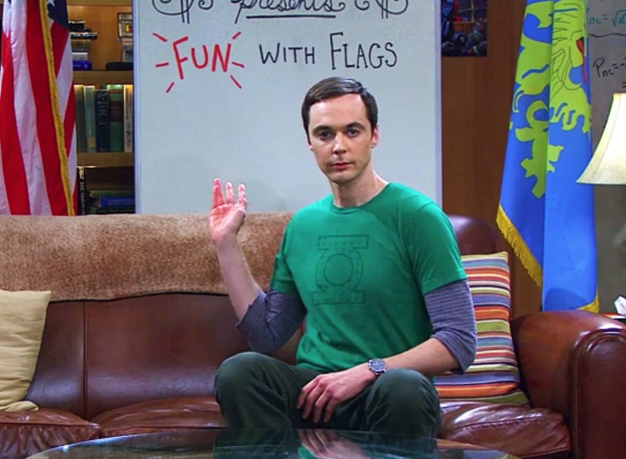 Sheldon Cooper on his couch, gesturing at his whiteboard behind him