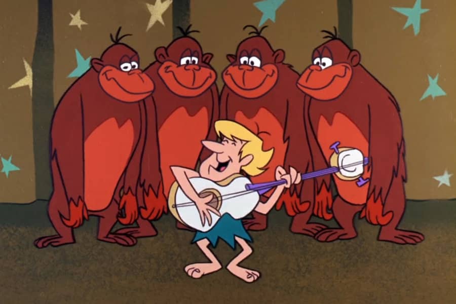 guy playing guitar with four gorillas behind him