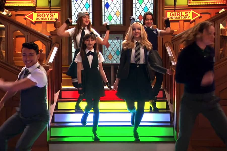 Stephanie, Ruby, and other students dancing down colorful stairs