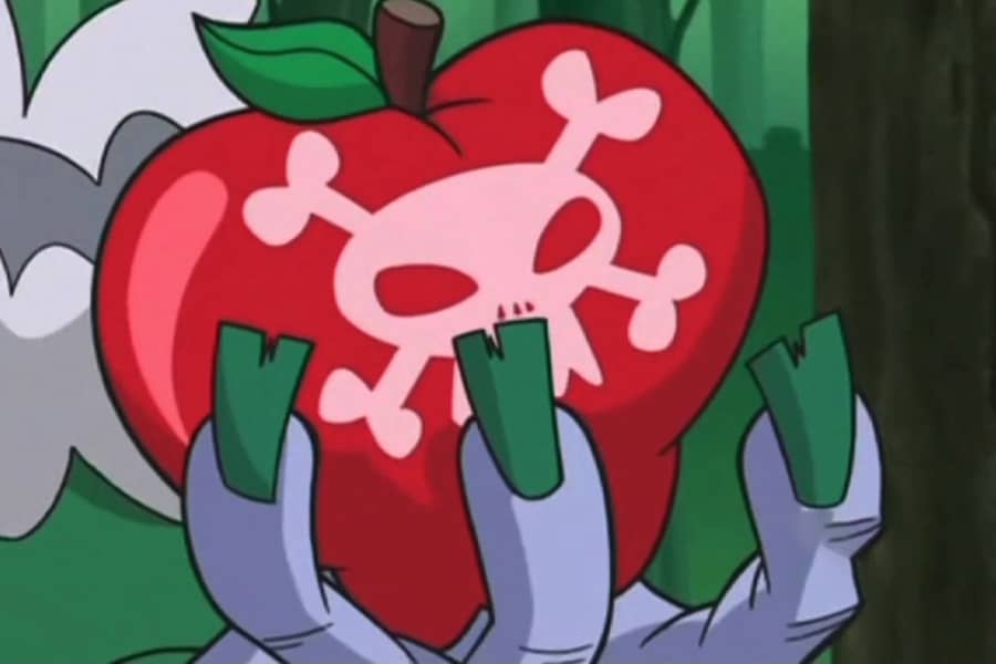 witch hand holding an apple with skull and cross bones on it