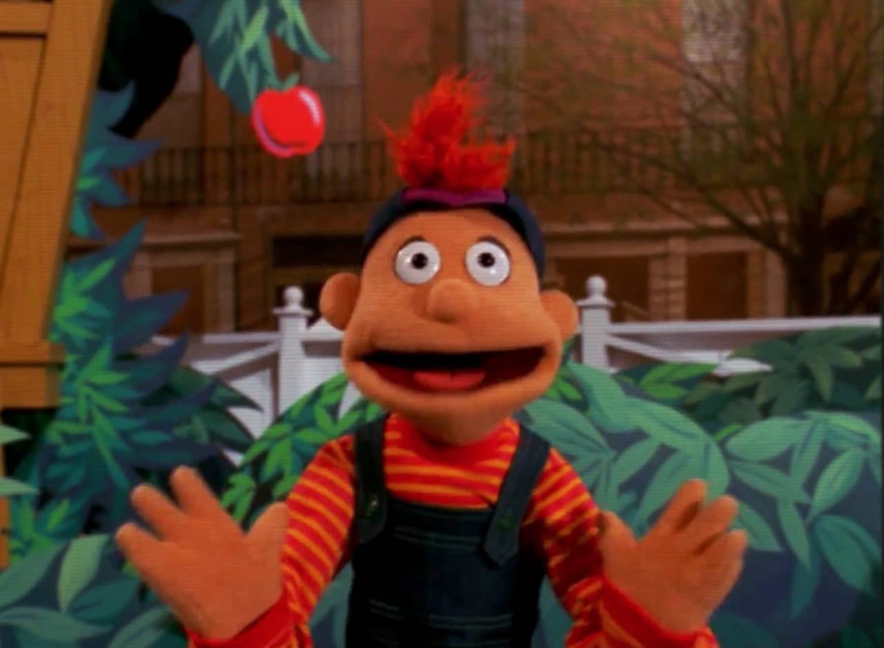 Polo, a happy puppet with overalls and backwards cap