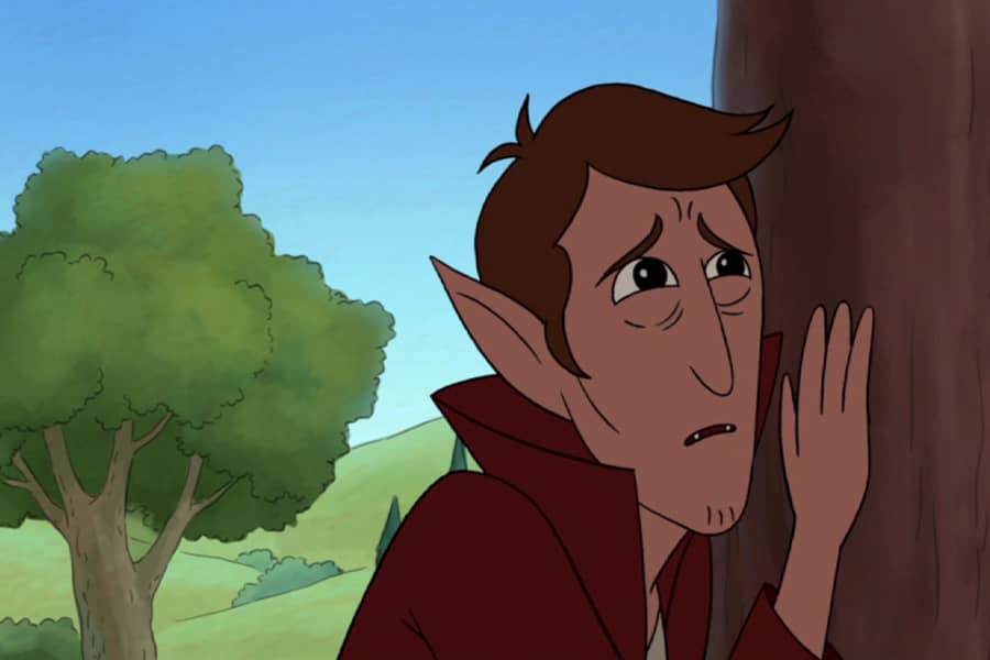 Christopher pining while leaning against a tree