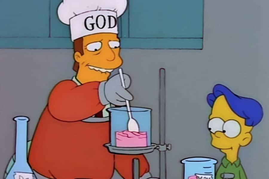 Troy McClure with a chef hat that says “God”, mixing pink liquid in a beaker