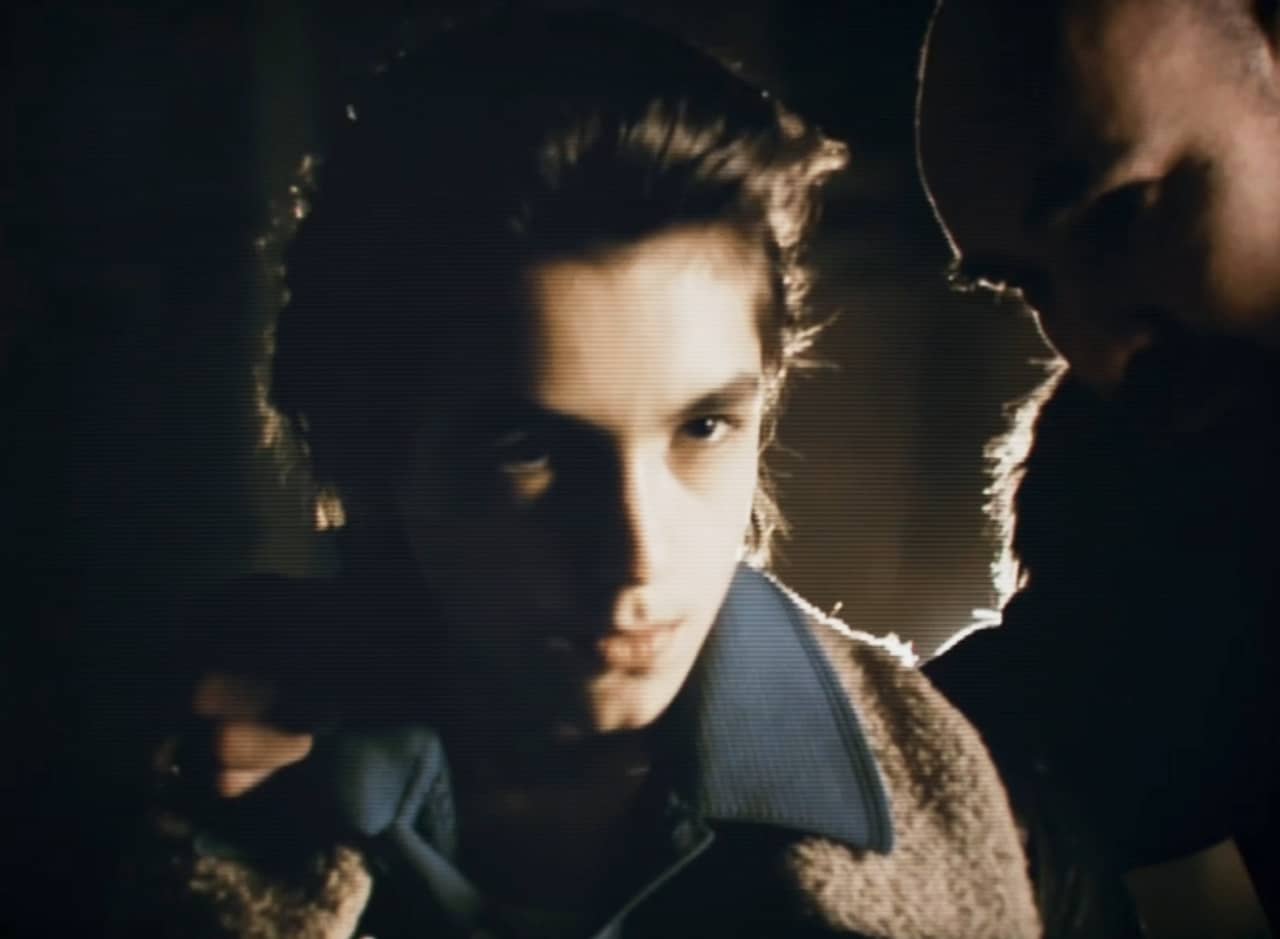 Tony, a young Italian boy, with his father whispering in his ear