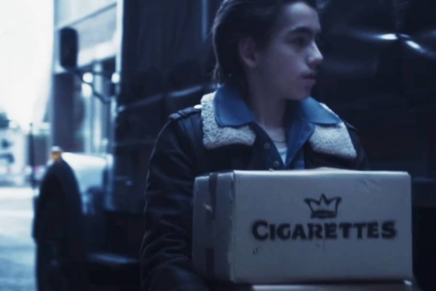 Tony carrying boxes of cigarettes