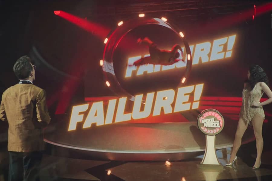 big letters say “Failure!” as Bud flips in the air within the wheel