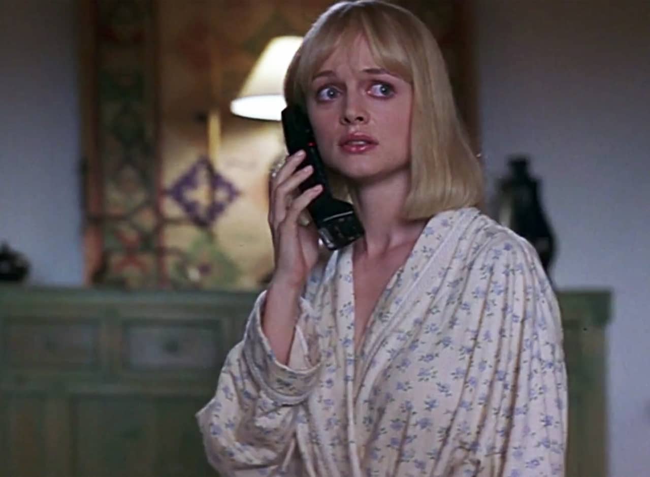 Heather Graham in a bathrobe looking scared on the phone