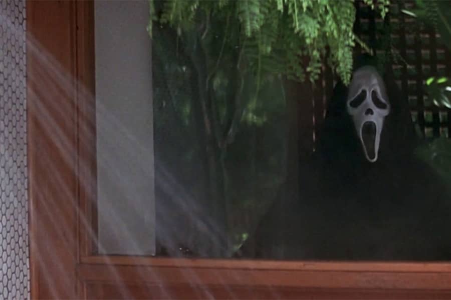 Ghostface looks into a window as a shower flows
