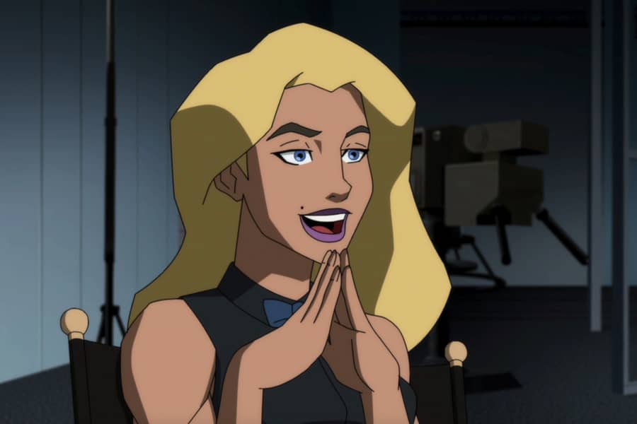 Whitmore with her hands under her chin, fingers touching