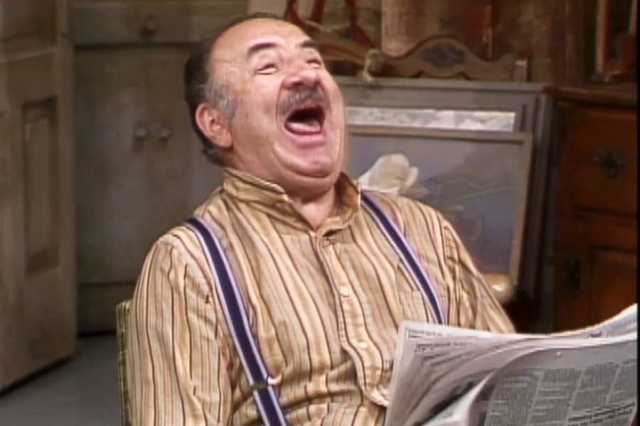father laughing while reading the paper