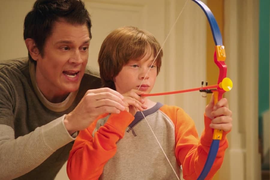 Jake teaching Cody to shoot a plastic bow and arrow