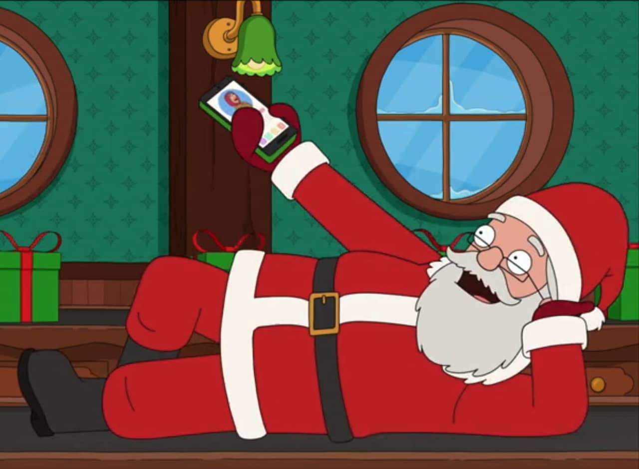 Santa reclining and holding up his smart phone