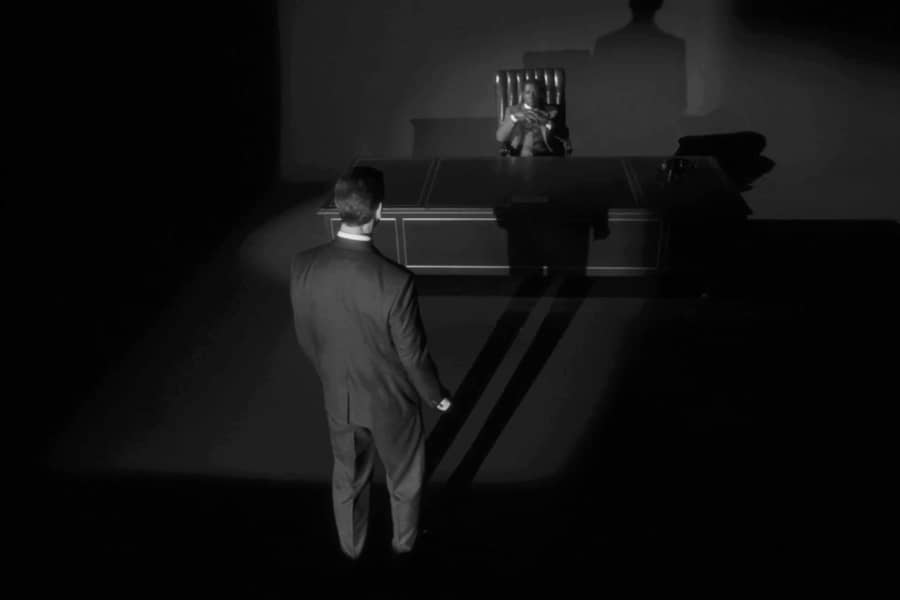 white man standing in front of his Black boss’s desk