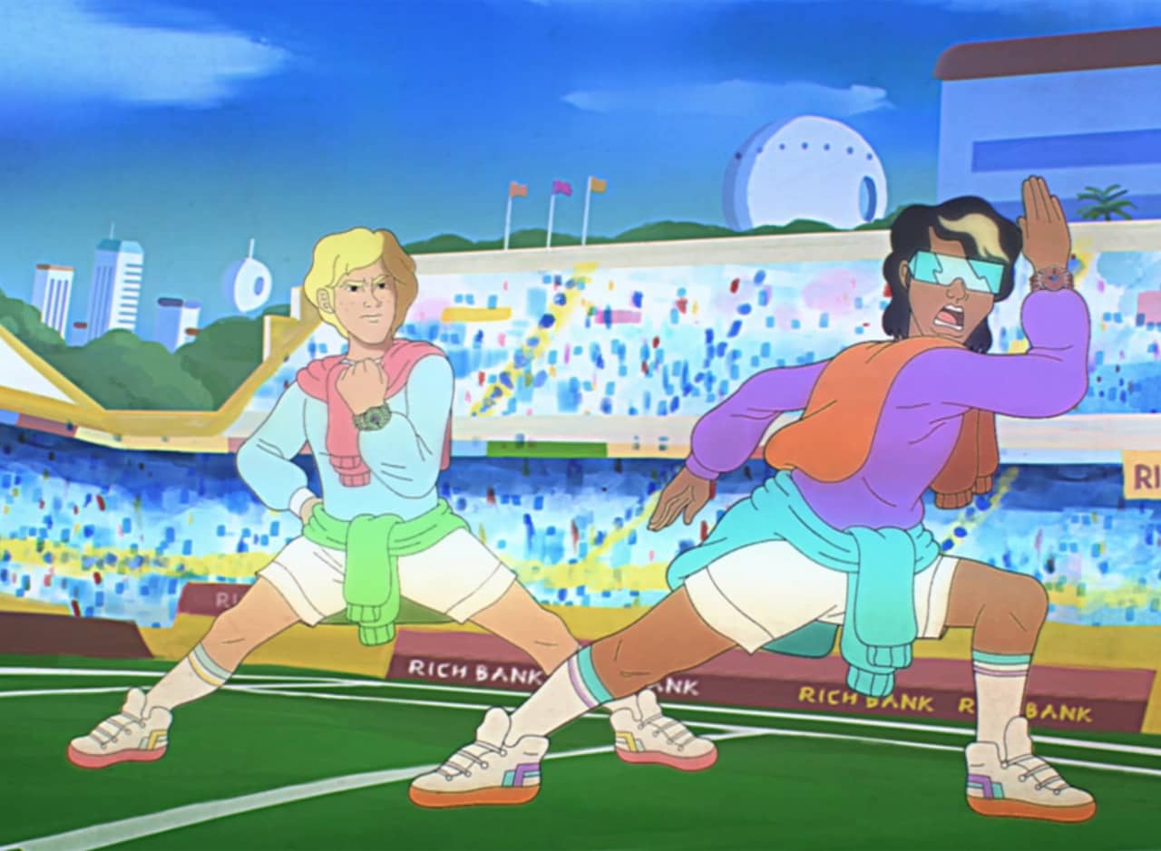 Troy and Carlton on a football field, they are in action poses and wearing multiple sweaters