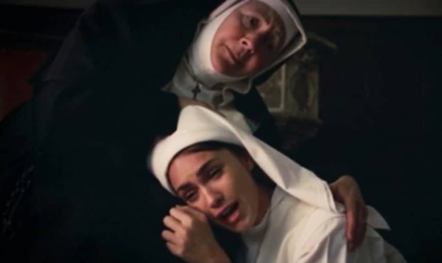 Teresa sobs in the lap of an older nun
