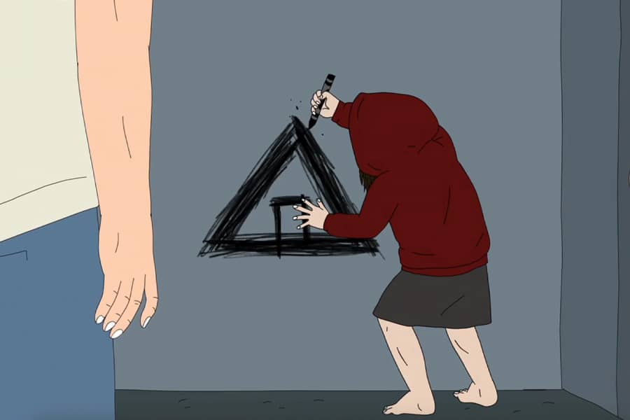 little girl in red hoodie scribbles an A-frame cabin on the wall with crayon