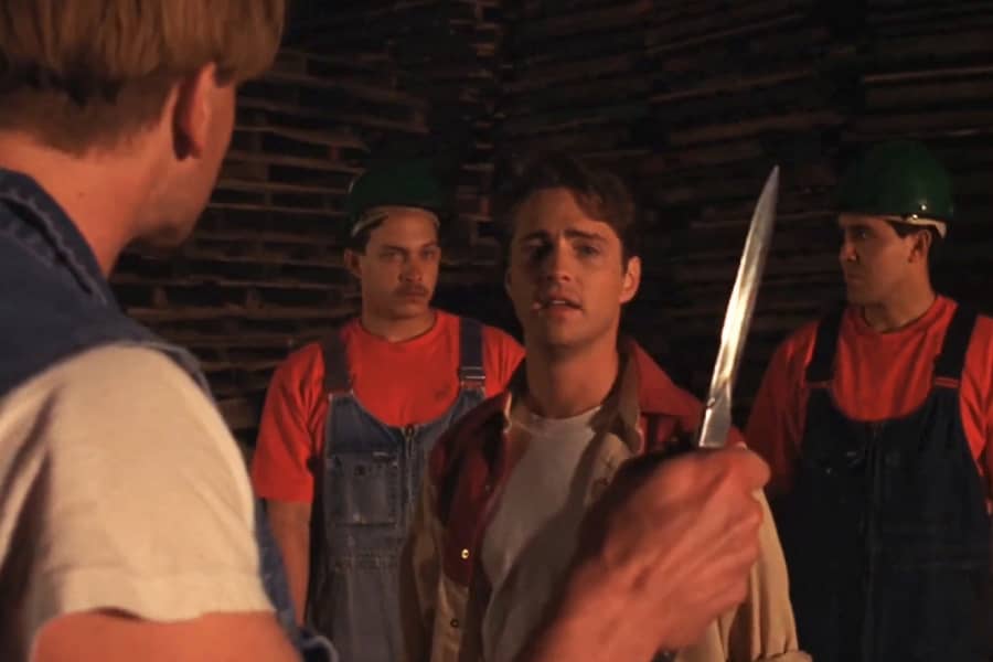 Jake pulls a knife on Johnny, who is standing in the way of two hispanic construction workers