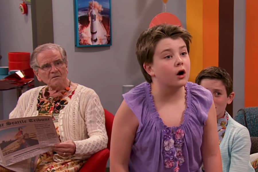 young son is surprised, both he and his grandfather in the background are in dresses