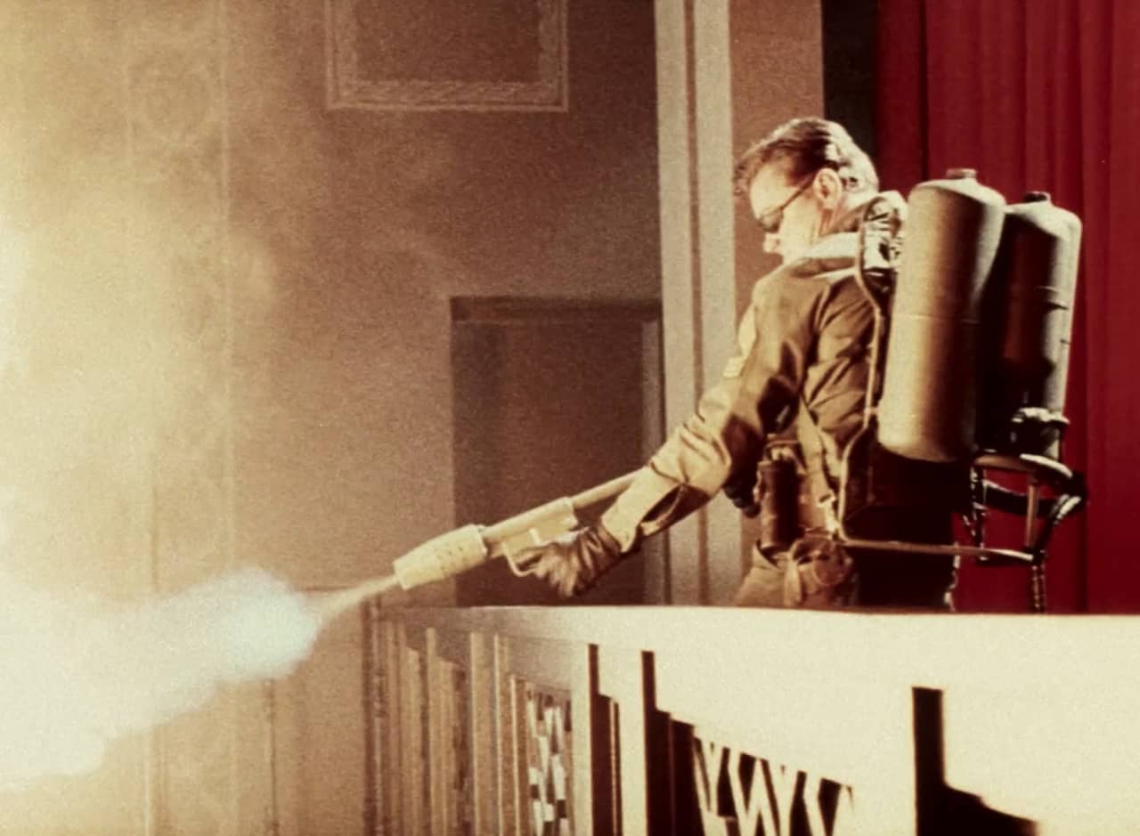 Rick Dalton as Sgt. Mike Lewis shooting a flame thrower from a balcony
