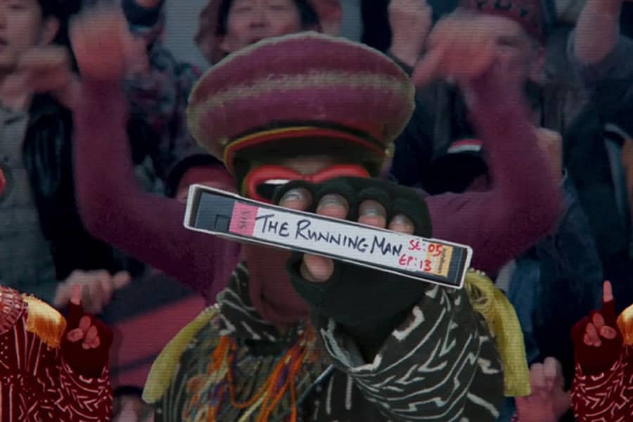 The Apostle holding a VHS tape labeled The Running Man Season 5 Episode 13