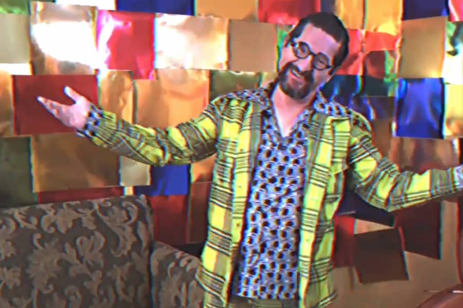 Bernardo in a plaid jacket in his living room set