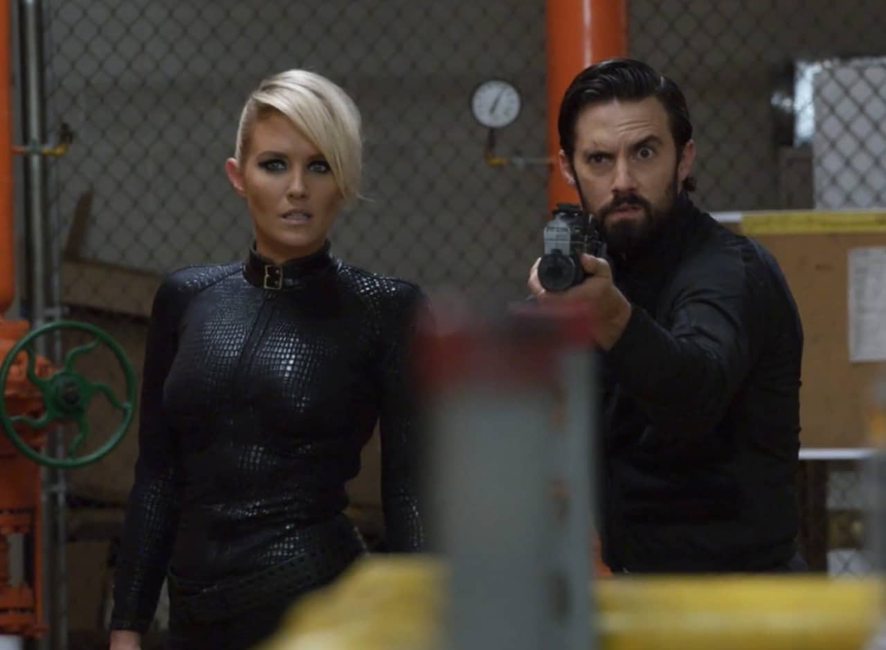 Agent Baker (Ventimiglia) and android L-E (Whelan) in a warehouse, Baker holding a gun