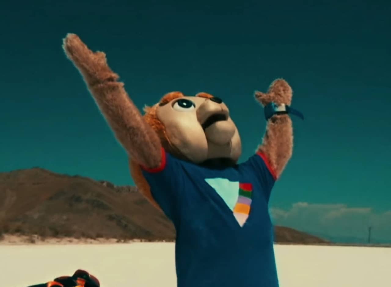 Brigsby Bear in the desert raising his arms to the sky