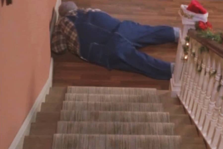 Grandpa Chunk laying on the floor at the bottom of the stairs