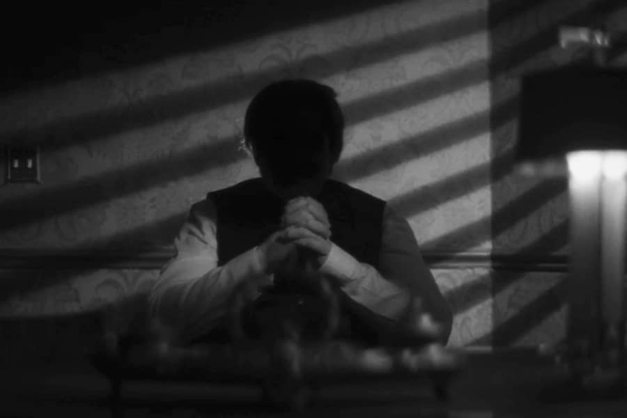 man sits in shadows