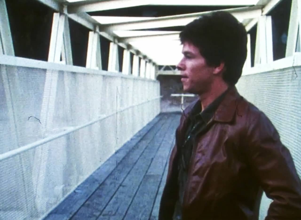 Dirk Diggler looks pensive while standing on a bridge