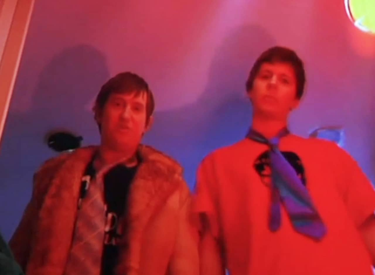 Matt and Owen wearing ties under red lighting