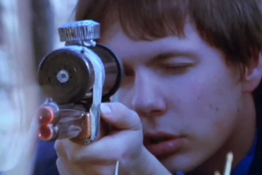 Owen looking into the scope of a gun