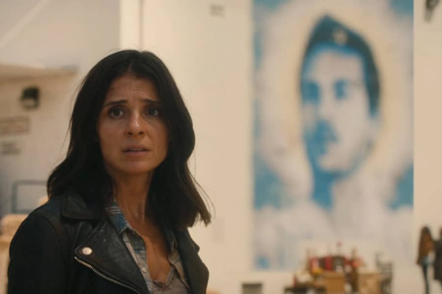 Shiri Appleby as Lisa, standing in front of a mural of Chester
