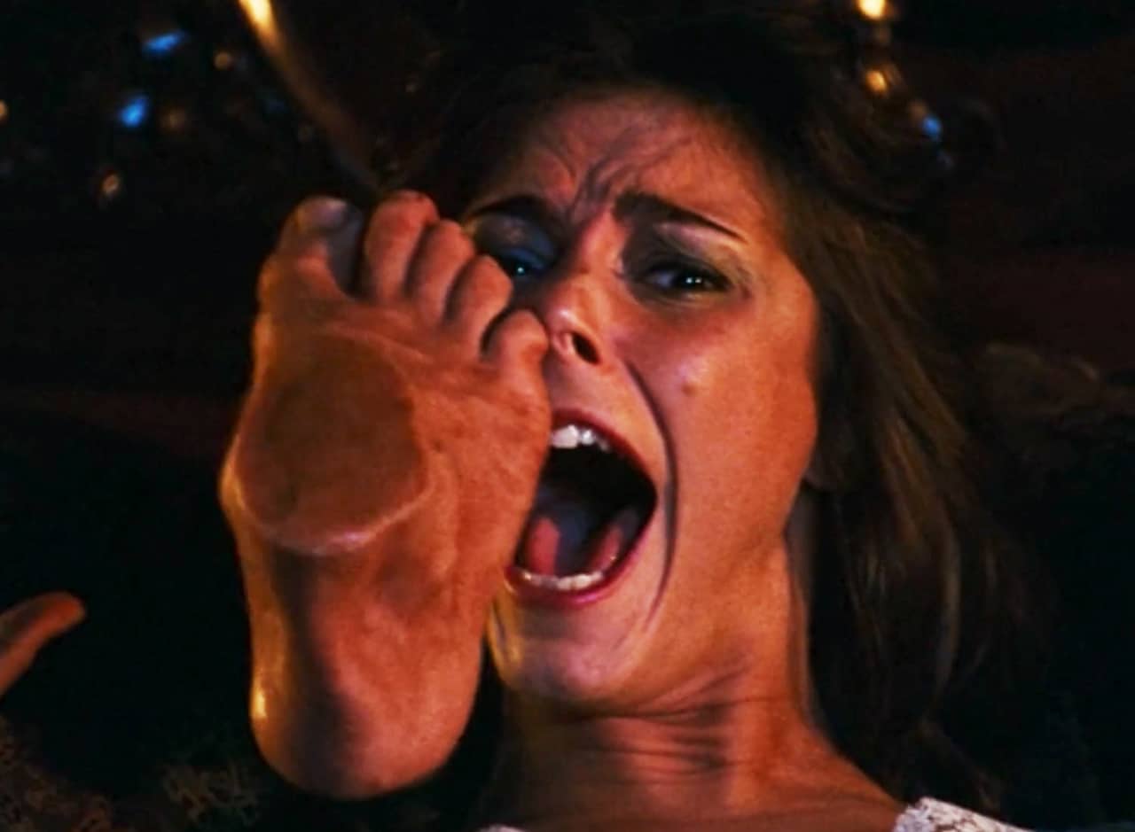 a severed foot sticks its pinkie toe into the nose of a screaming woman