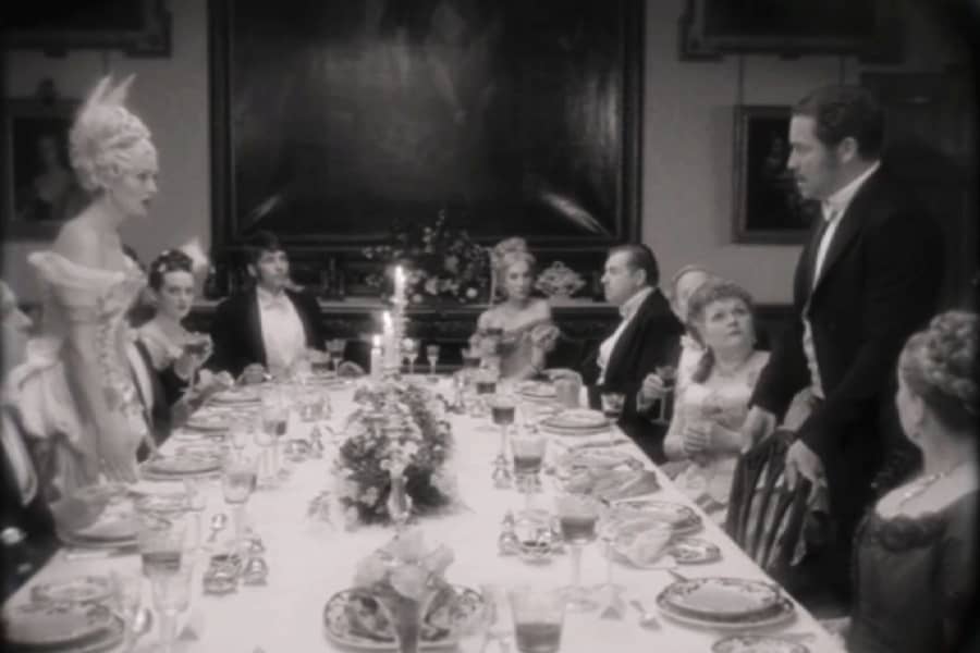 Bill and Lady Anne stand and speak across a long dinner table full of people